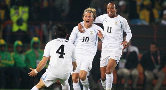 Denis Ahogo (izquierda), Diego Forlan (centro) y Alvaro Pereira (derecha) de la seleccin uruguaya de futbol